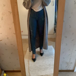 Blå skinny jeans med hög midja - Säljer ett par klassiska blå skinny jeans med hög midja och resår i midjan. Jeansen har en enkel bakficka och är i stretchigt material som sitter tight längs benen. Perfekta till vardags och lätta att matcha med olika toppar.