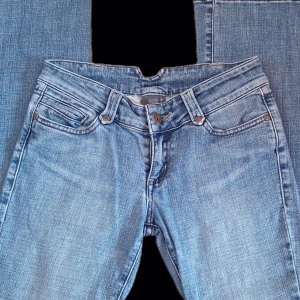 Ljusblå lågmidjade bootcut jeans  - Säljer ett par ljusblå bootcut jeans, Stl S men se måtten! Innerbenslängd: 76 cm