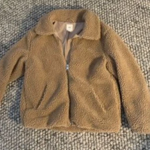 Teddyjacka  - Mysig beige teddyjacka med krage och dragkedja framtill. Nypris: ca 550 Mitt pris: 199. Använd ca 5 ggr.