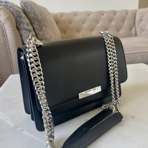  Michael Kors väska - Axelväska från Michael Kors i slätt skinn med silverfärgad kedjerem. 