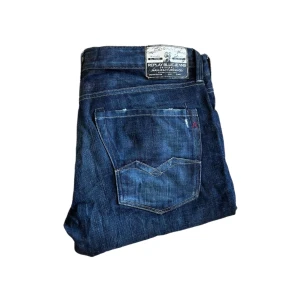 Replay Waitom Barcelona jeans  - Snygga Replay waitom jeans i mörkblå tvätt med klassiska raka ben och femficksdesign. Jeansen har tydliga kontrastsömmar, läderpatch bak och detaljerad bakficka. Tillverkade i slitstark bomullsdenim, perfekta för en avslappnad och stilren look. Längd ca 100cm. Jag skickar ej bild när jag bär plaggen och jag vet ej vilken längd och vikt de passar då jag inte prövar kläderna jag säljer 😃