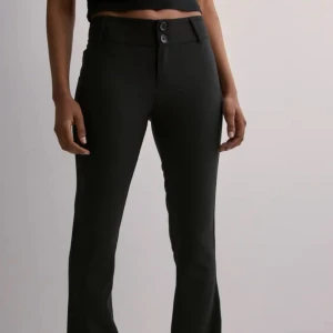 Svarta bootcut kostymbyxor - Snygga svarta kostymbyxor med bootcut-snitt och hög midja. Byxorna har två knappar framtill och fickor med lock och knapp bak. Perfekta för en clean och stilren look. Materialet är slätt och stretchigt för extra komfort💗
