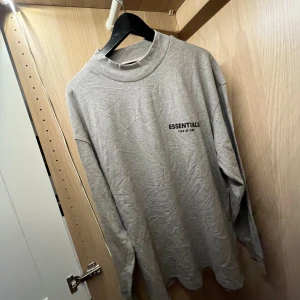 Grå långärmad Essentials Fear of God - Säljer denna gråa långärmade essential tröja 