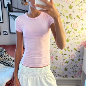 Ljusrosa topp från Gina Tricot - Supersöt ljusrosa topp från Gina Tricot i .perfekt för en enkel och clean look. Mjuk och stretchig i bomullsmix som känns skön mot huden.