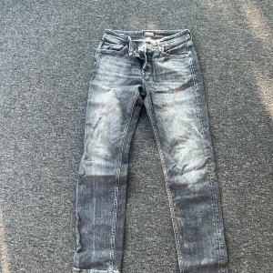 Gråa jeans i rak modell, 29/32 - Säljer ett par gråa jeans med snyggt tvättad look och klassisk rak passform. Jeansen har fem fickor, dragkedja och knapp i midjan. Perfekta för dig som gillar en stilren och enkel vibe. Materialet är slitstarkt denim i bomull.