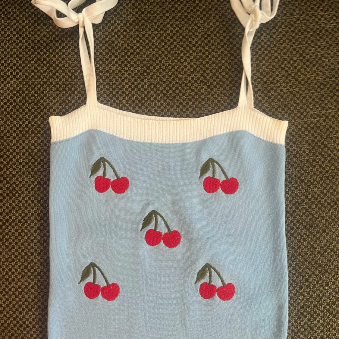 Ljusblå stickad linnetopp med körsbär