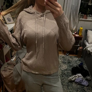 Beige ribbad hoodie från 157 - Säljer en beige hoodie från 157 i storlek S. Tröjan är ribbad med snygga vertikala ränder, har huva med snörning och långa ärmar. Perfekt för chill dagar och har en loose passform som är riktigt skön. Materialet känns mjukt och är stickat.