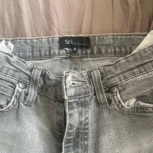Grå jeans från Sisters, storlek 36 - Snygga grå jeans från Sisters i klassisk femficksmodell. Jeansen har en ljusgrå tvätt, raka ben och coola detaljer på bakfickorna. Perfekta för dig som gillar en avslappnad och stilren look.