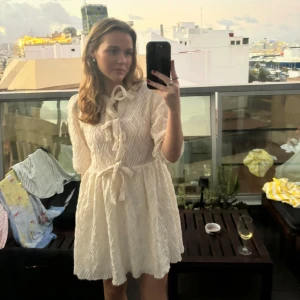  kortklänning från Gina Tricot - Supersöt kortklänning från Gina Tricot med puffärmar och knytband både i midjan och vid halsen. Klänningen har ett snyggt strukturerat mönster. Använd 1 gång💕☺️