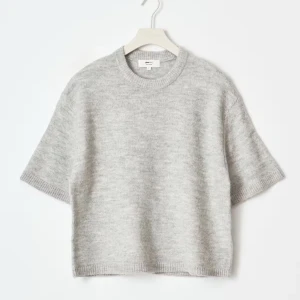 Grå stickad kortärmad tröja - Supermjuk och stilren grå stickad tröja från Gina Tricot. Tröjan har korta ärmar, rund halsringning och en relaxed fit som passar perfekt till jeans eller kjol. Enkel design med ribbade kanter för en clean look.