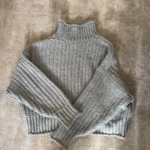 Grå stickad polotröja från H&M - Säljer en chunky grå stickad polotröja från H&M i storlek XL. Tröjan har en hög krage, breda ribbade muddar och är tillverkad av 90% akryl och 10% ull. Perfekt för kyliga dagar och har en loose fit som ger en chill vibe.