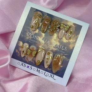 Solar (S);Medium Almond - Handgjorda press on-naglar i nude med lyxiga gulddetaljer, glitter, stjärnor och 3D-rosetter. Naglarna har en medium almond form och kommer i S: 15 mm, 11,5 mm, 12 mm, 11 mm, 9 mm. Perfekt för dig som vill ha en glam och unik look. 