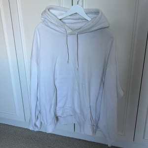 Vit hoodie från Weekday i storlek L - Säljer en oversized vit hoodie från Weekday i storlek L. Tröjan har huva med snörning, stor magficka och långa ärmar. Perfekt för chill dagar eller när du vill ha en enkel och clean look.