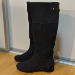 Svarta mocka stövlar med klack - Oanvända snygga svarta stövlar från Gabor i mocka med rund tå och stabil klack. Stövlarna har dragkedja på insidan och en stilren design som passar perfekt till höst- och vinterlooken. Klassisk modell med platt sula framtill.