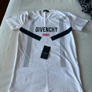 Givenchy t-shirt  - Snygg vit t-shirt från Givenchy Paris i bomull. Framsidan har coolt grafiskt tryck med svarta och röda detaljer samt Givenchy-logga. T-shirten är använd en gång, vid frågor eller fler bilder är det bara att skriva.