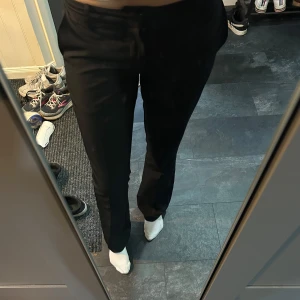 Svarta kostymbyxor från BikBok - Säljer ett par svarta kostymbyxor med låg midja från BikBok i storlek 38. Sprättade längst ner och passar bra i längden på mig som är 178cm🩷