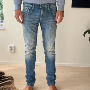 Replay  jeans herr - Snygga Replay jeans i ljusblå tvätt med slitningar och klassiska fem fickor. Jeansen har normal passform och raka ben. Storlek W32 L34