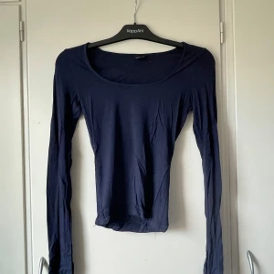 Uringad topp  - En enkel mörkblå långärmad topp från Gina Tricot. Den är urringad och är figurnära i passformen💕💕