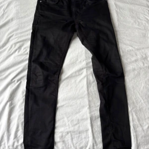 Svarta Nudie Jeans - Ett par feta Nudie Jeans i svart storlek 32/34 OBS passar även dig som brukar ha 30/32!! Skriv privat för fler frågor, bilder osv‼️