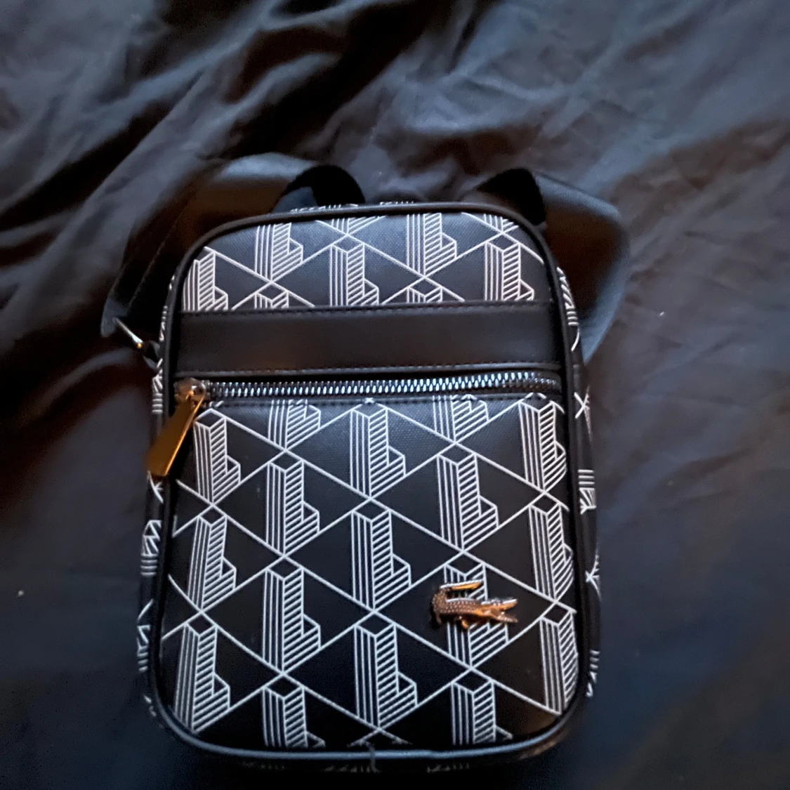 Svart axelväska från Lacoste med mönster