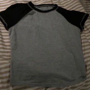 Grå/svart baby tee - En kort grå topp med svart där uppe. Den har använts 2 gånger och är som ny🥰