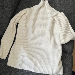 Vit ribbad polotröja - Säljer en stilren vit ribbad polotröja med långa ärmar. Tröjan har en halvhög krage.
