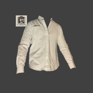 Vit och blå randig skjorta från Matinique - 👔Snygg vit och blå randig skjorta från Matinique i storlek M. Skjortan har långa ärmar och klassisk krage med knappar. Perfekt för en stilren look. Inga defekter. Nypris 999kr 👔