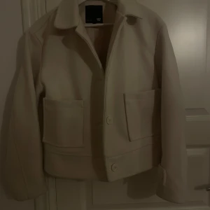 Kappa  - Snygg beige jacka från 157 med stora fickor och knappar framtill. Jackan har en klassisk krage och en stilren design som passar perfekt för höst och vår. Den är långärmad och har en normal passform.❤️Pris kan diskuteras❤️