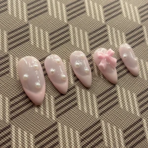 Rosa naglar med pärlor och rosett💕 - Tumme: längd-25,40mm brädd-11,40 Pekfinger: längd-21,30mm brädd-8,90mm Långfingret: längd-20,80 brädd-8,60 Ringfinger: längd-21,30mm brädd-8,90mm Lillfinger: längd-18,50mm brädd-07,00mm❤️ Det ingår lim, liten nagelfil och för att fixa sina nagelband!🥰