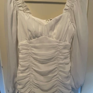 Vit klänning  - Jättefin Vit, lite tightare klänning med pösiga ärmar. Köpt här på Plick men eftersom den var lite liten runt höfterna på mig testar jag och sälja vidare den. Inga tecken på användning då tjejen jag köpte den av bara hade använde den en gång. Bara att höra av dig om du har frågor🥰pris går att diskutera