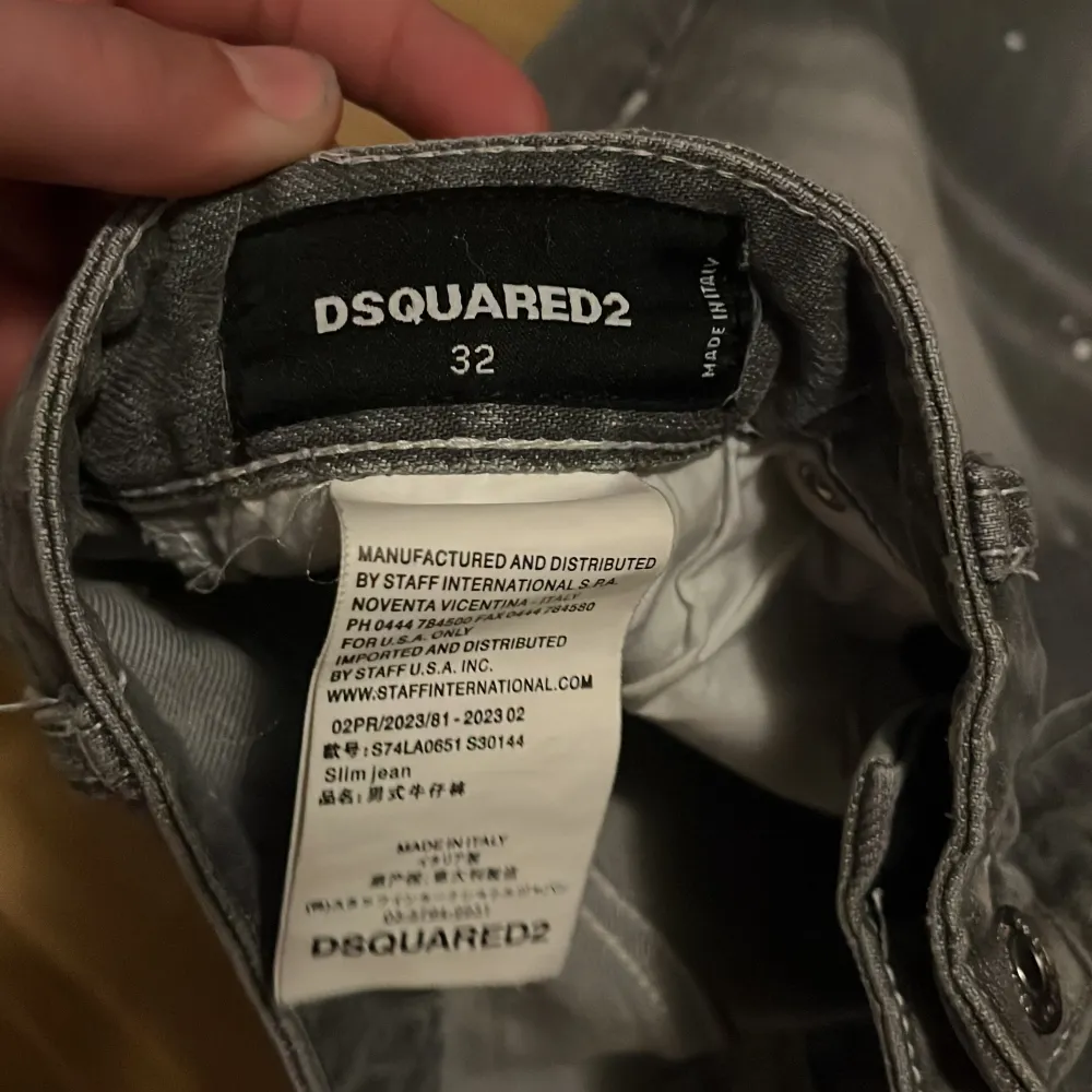 Snygga grå jeans från Dsquared2 med coola slitningar och färgstänk. De har en slim passform och är tillverkade i Italien. Perfekta för en trendig look med unika detaljer som ger en edgy stil.. Farkut & Housut.