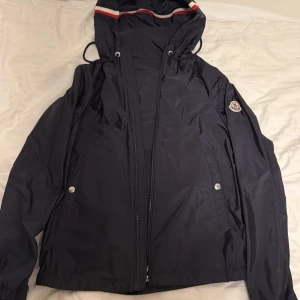 Mörkblå windbreaker från Moncler - Säljer en snygg mörkblå windbreaker från Moncler . Jackan är i fantastiskt skick inte använd så mycket. Jackans nypris är 8999kr, storlek 1!