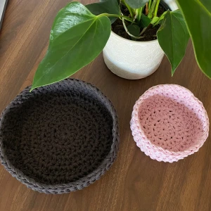 Handgjorda virkade korgar i 🩷 och 🤎 - Två handgjorda virkade korgar, en i ljusrosa och en i mörkbrun. Perfekta för förvaring eller som dekorativa inslag i hemmet. Korgarna är runda och har en fin, tät virkning som ger dem en stabil form. Lilla korgen är 12 cm och stora är 20 cm i diameter och båda är 6 cm höga!