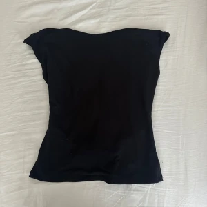 Backless top från Gina triccot  - Tröjan är hel svart och har en öppen rygg, den är helt oanvänd och lappen sitter kvar. 