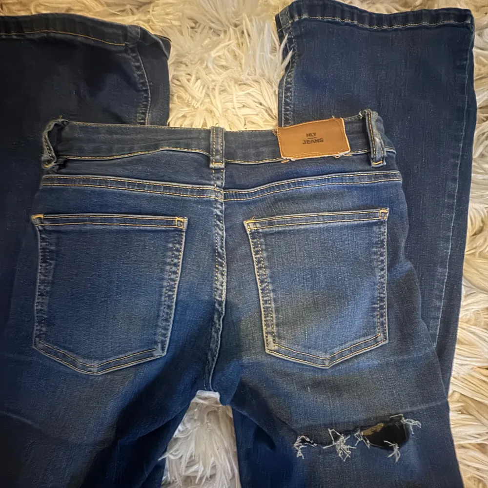 Säljer ett par blå jeans med slitningar på ena benet lågmidjade jeans. . Farkut & Housut.