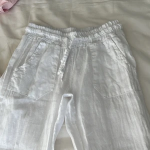 Vita linnebyxor  - Fina lågmidjade linnebyxor med fickor där fram och bak. Jag kommer inte ihåg storleken men vill ni ha mått? Kom privat. De är lite uppsydda men går nog bra att ta bort. Säljer dom då de är för små men är nästan inte använda. Köpte dem förra sommaren
