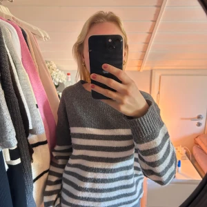 Grå och vit randig stickad tröja - Säljer en mysig grå och vit randig stickad tröja från Shein med långa ärmar. Perfekt för kyliga dagar. Tröjan har en klassisk design med breda ränder och en bekväm passform.💞