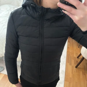 Svart Vårjacka - Säljer en stilren svart dunjacka med huva. Sparsamt använd. Lite mindre i storleken🤍