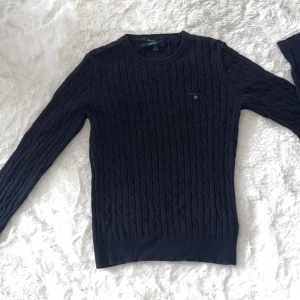 Mörkblå kabelstickad tröja från GANT - Snygg mörkblå kabelstickad tröja från GANT i stretchig bomull. 