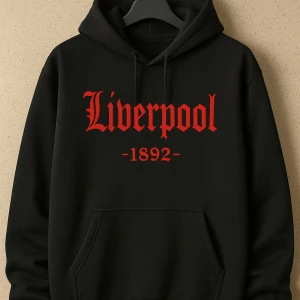 Svart Liverpool hoodie med röd text - Svart hoodie med huva och snörning, stor röd text 'Liverpool' och '1892' på bröstet. Klassisk kanguruficka framtill och mjukt material, perfekt för dig som vill visa support för Liverpool FC. Snygg och enkel design med lång ärm.