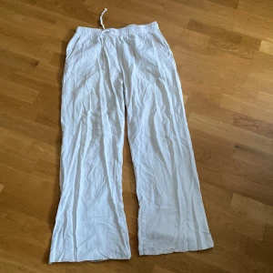 Vita linnebyxor med snörning, lager 157 S - Luftiga vita linnebyxor från lager 157 i storlek S. Byxorna har elastisk midja med snörning, raka ben och fickor både fram och en bak. Perfekta för varma dagar, lite slitage vid fotändan. Du står för frakten, vid mer info skriv