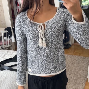 Mönstrad blåvit tröja Odd Molly - Säljer en snygg långärmad tröja från Odd Molly i blått och vitt med ett unikt mönster. Tröjan har en rundad halsringning med snörning och tofsar framtill, samt ribbade kanter! 