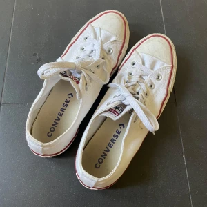 Vita Converse All Star sneakers - Klassiska vita Converse All Star sneakers med lågt skaft, röda detaljer och vita snören. Skorna har rund tå, platt sula. Riktigt sköna och snygga skor passar till allt! 