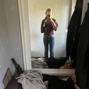 Blå bootcut jeans med broderade fickor - Säljer ett par blå bootcut jeans med snygga broderade detaljer på bakfickorna och kontrastsömmar. Jeansen har låg midja och klassisk femficksdesign. Finns mer bilder om det önskas