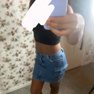 Blå jeanskjol med fickor från Wow - Säljer en snygg blå jeanskjol från Wow i storlek 146. Kjolen är kort och har coola fickor på sidorna samt klassiska jeansdetaljer med knapp och dragkedja framtill. Perfekt för dig som gillar streetstyle och vill ha en chill look.