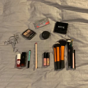 Stort sminkpaket med borstar och paletter - Säljer ett komplett sminkkit (testade produkter) med flera ögonskuggspaletter i nude, bruna och blå toner, läppglans i rosa och nude, röd läppstift, läppenna, eyeliner i turkos, ögonfransböjare i metall, sminkborstar (är testande men är diskade och rengjorda) från real techniques och andra märken. Perfekt för dig som vill testa olika looks!