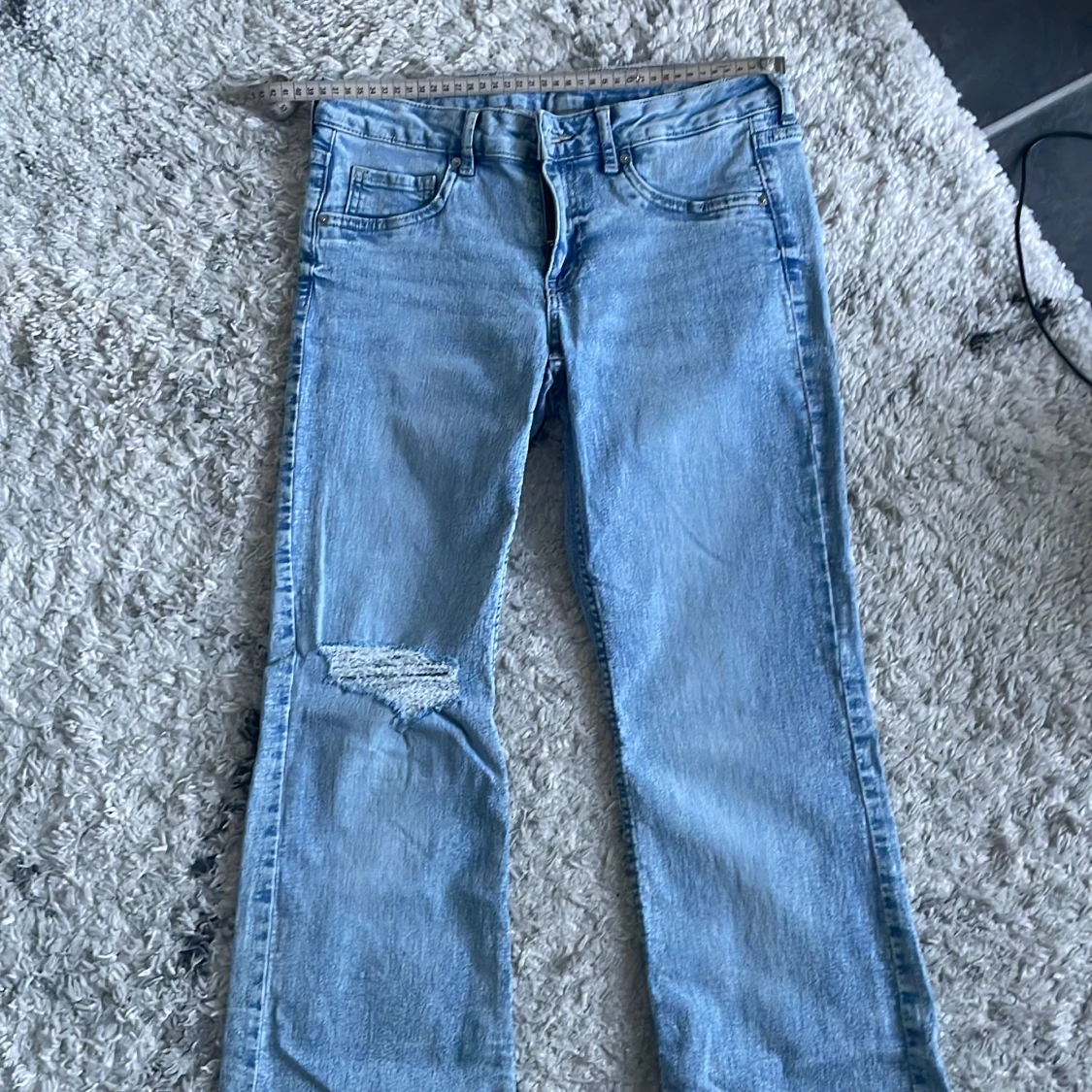 Ljusblå bootcut jeans från HM slitning