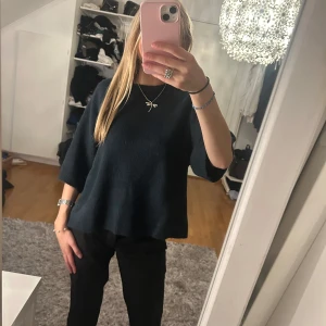 Mörkblå stickad tröja  - Säljer en mörkblå stickad tröja med korta armar. Tröjan är i nyskick och knappt använd 