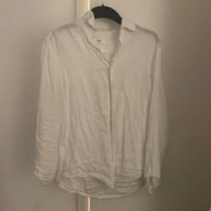 Vit linneskjorta från Uniqlo XS - Klassisk vit skjorta från Uniqlo i storlek XS. Skjortan är tillverkad i svalt linne, har lång ärm, krage och knäppning framtill. Perfekt för en clean och avslappnad stil, lätt att matcha med jeans eller shorts.