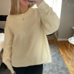 Krämvit stickad tröja med rund hals - Mysig krämvit stickad tröja med rund halsringning och långa ärmar. Tröjan har en relaxed fit och ribbade muddar vid ärmslut och nederkant. Perfekt för lager-på-lager och chill dagar. Den är storlek M men funkar för S med, jag har normalt Xs och S💕